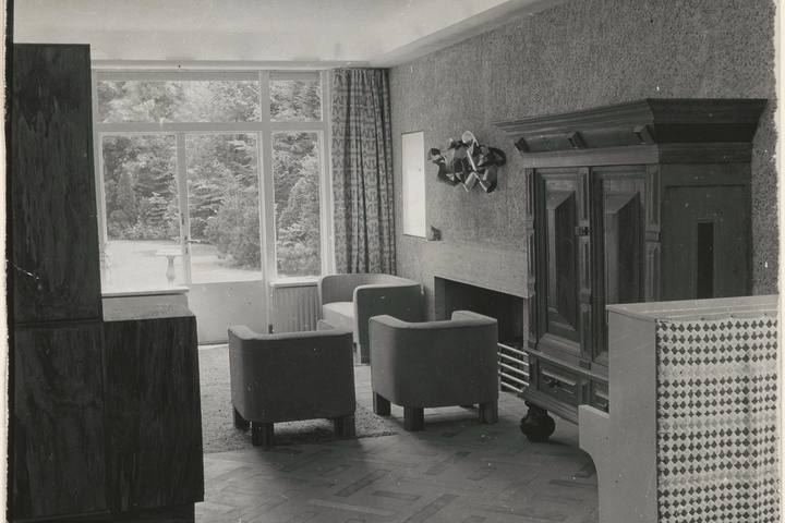 Afbeelding van woonkamer Redelé, zithoek met fauteuils bij open haard
