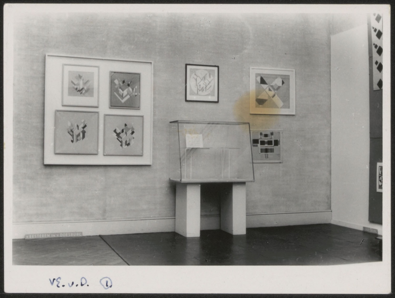 Afbeelding van tentoonstelling De Stijl SMA, 1951, zaal 1, wand Van Doesburg met vitrine