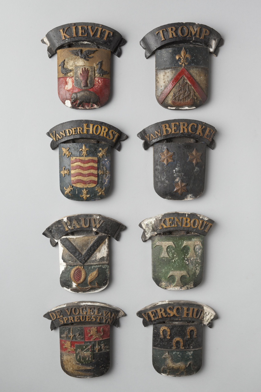 Acht houten wapenschildjes