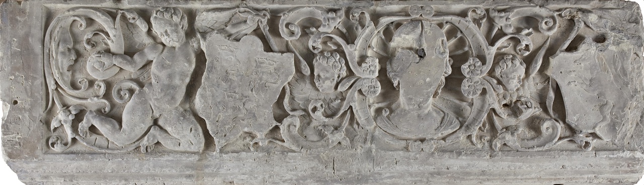 Schoorsteenfries met vrouwenhoofd in een schelpnis, cherubkopjes en een wapendragende engel