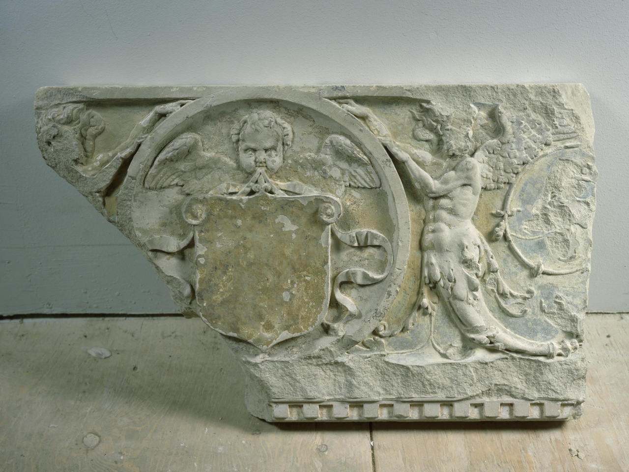 Schoorsteenfries, fragment met wapendragende cherubijn en gevleugelde saters
