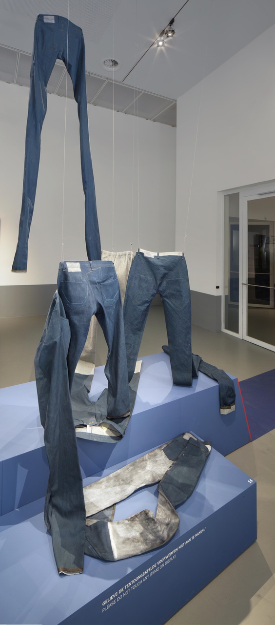 Installatie Zonder titel bestaande uit 8 spijkerbroeken