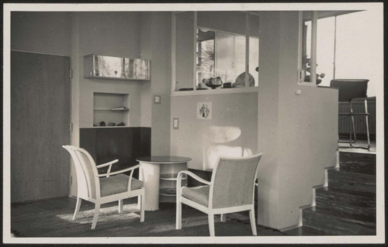 Afbeelding van woning Hillebrand, ca.1935, twee stoelen bij tafeltje in openhaard hoek