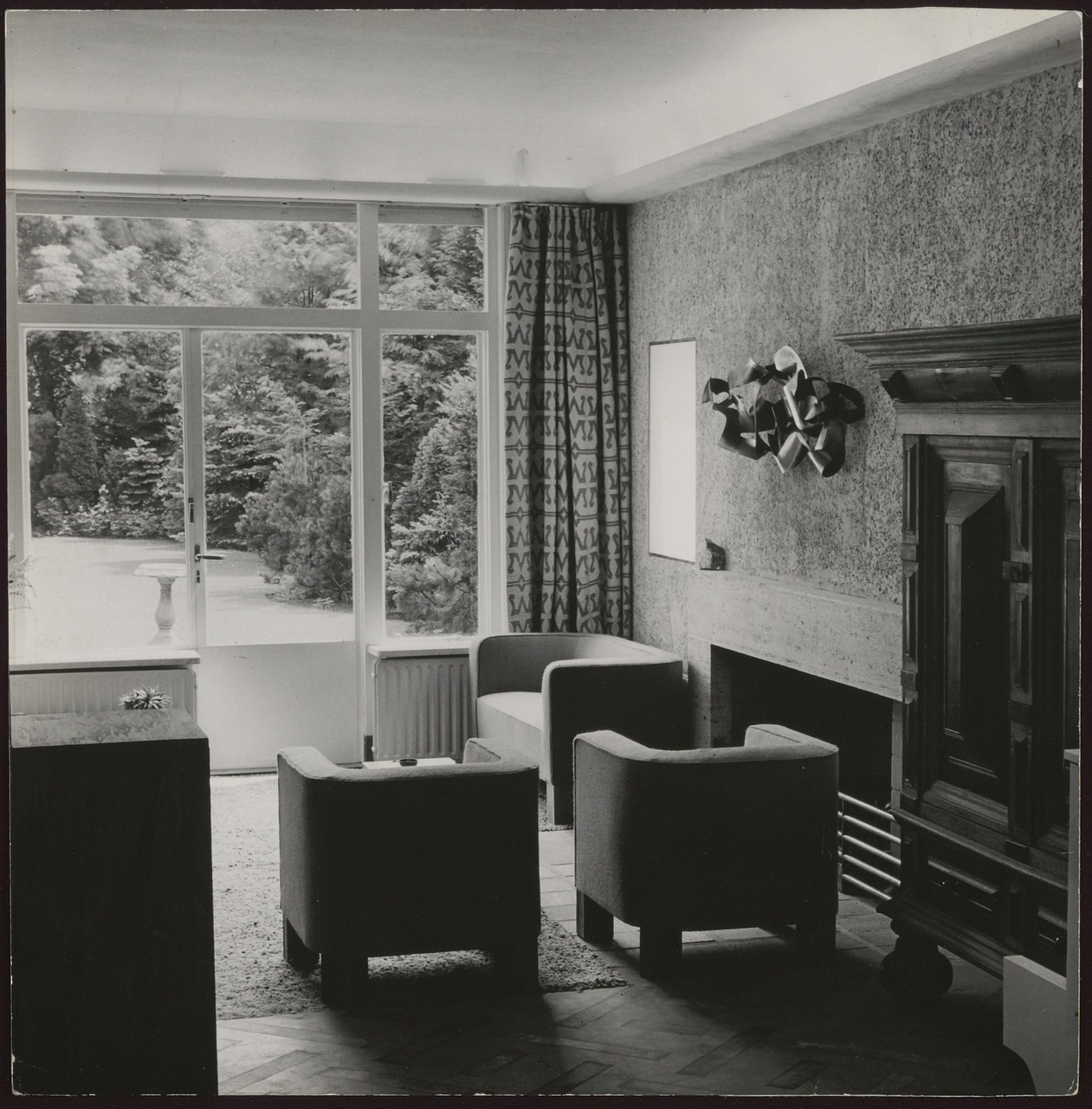 Afbeelding van woonkamer Redelé, zithoek met fauteuils bij open haard