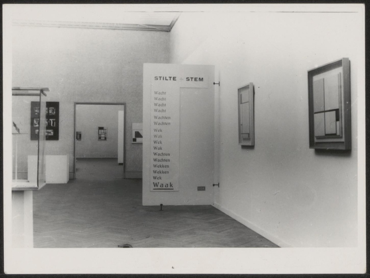 Afbeelding van tentoonstelling De Stijl SMA, 1951, zaal 4, schot met dada-tekst Stilte-Stem