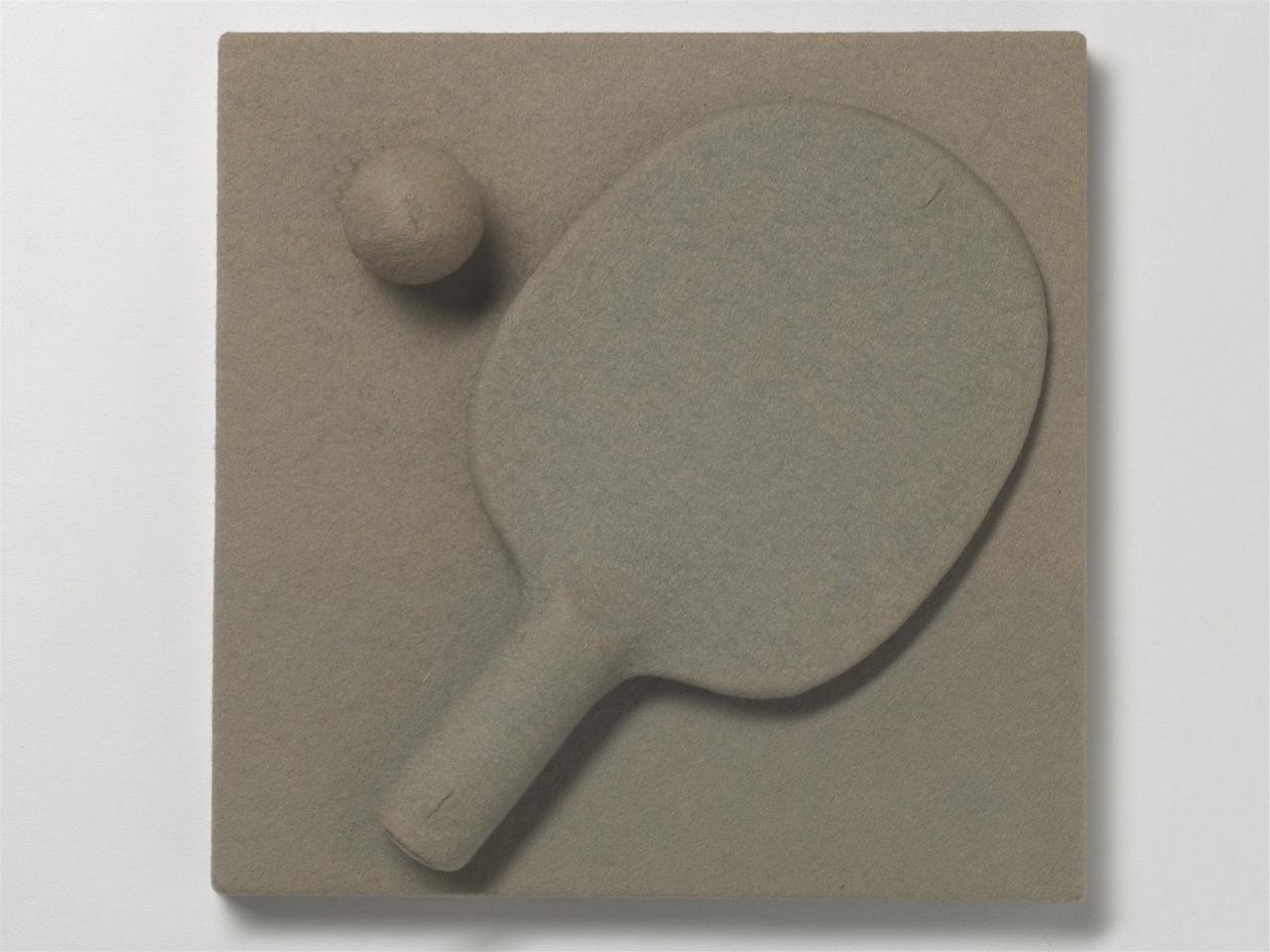 Een pingpongbatje en een pingpongbal overtrokken met vilt, het kunstwerk 'Zonder titel' van Wim T. Schippers uit 1965.