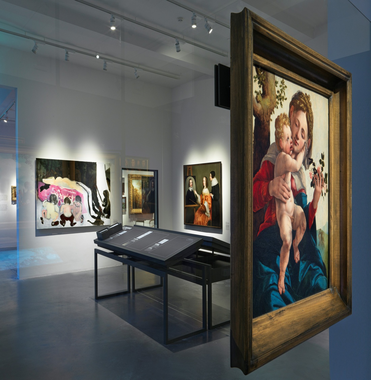 Museumzaal met schilderij op glazen wand en overige wanden, schuin oplopende displaytafels in het midden